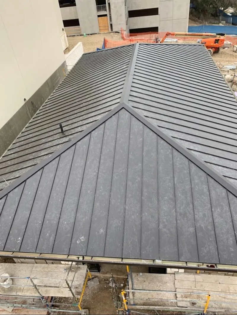 Commercial metal roof construction with crane equipment in Fairmont